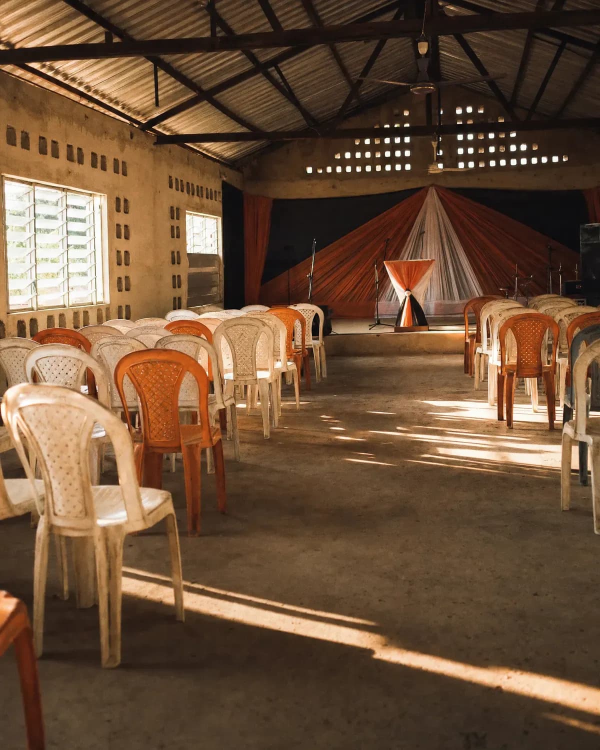 An empty parish hall with light falling through louvre windows